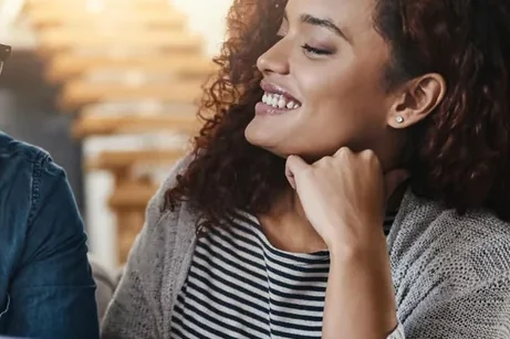 Mulher sorrindo, apoiada na mão, durante um atendimento